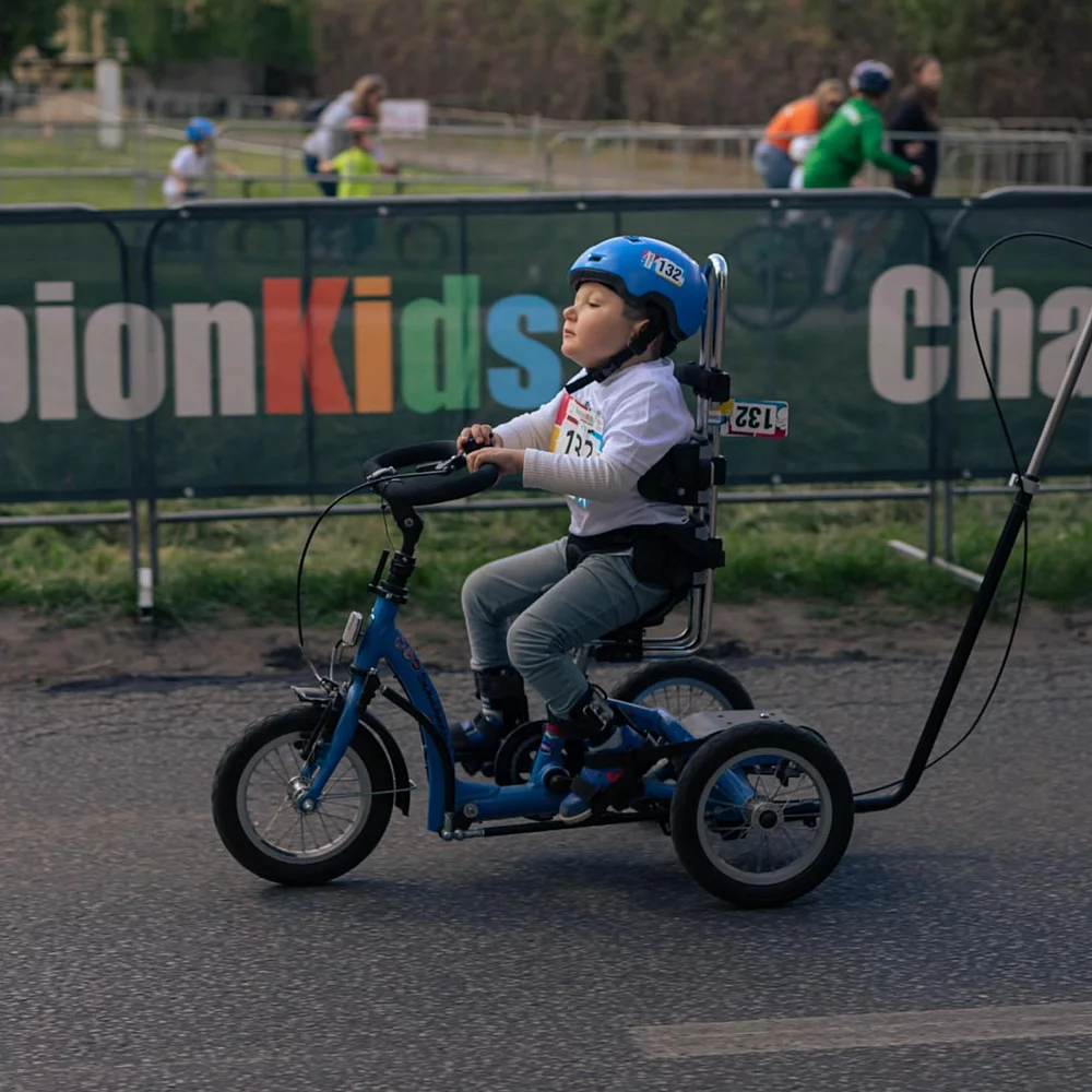 Young boy with his momo dreirad focussed on the track
