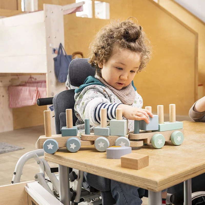 A child is sitting at the table and playing with a toy